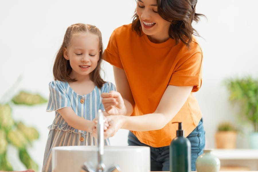 Mother and daughter washing their hands together