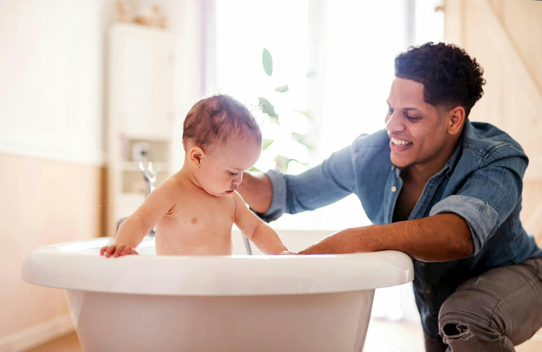 Father bathing his child in a tub